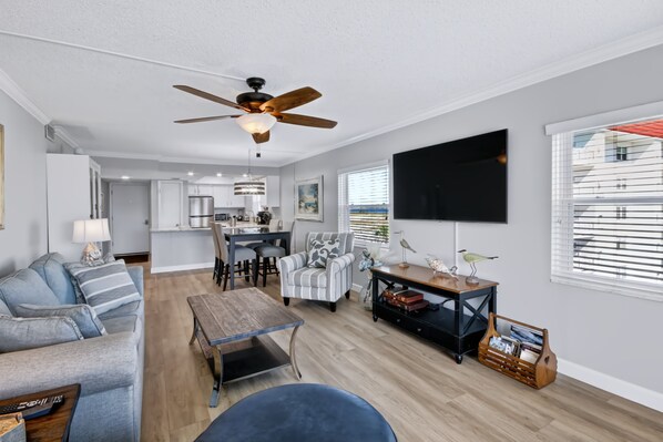 Un salon moderne avec un canapé, une table basse et un téléviseur fixé au mur.