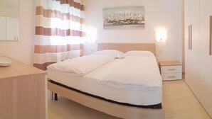 Ein Hotelzimmer mit Bett, Nachttisch und einem Bild an der Wand.