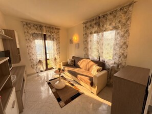 A living room with a sofa, coffee table, and curtains.