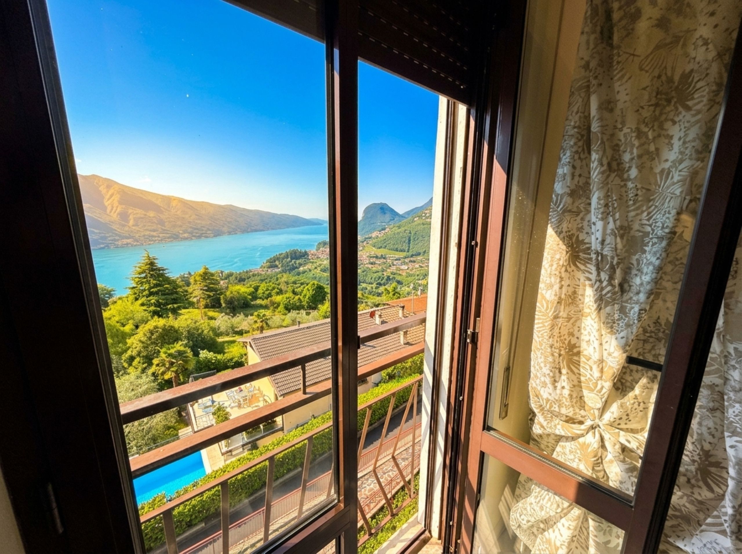 A balcony with a view of a lake and mountains.