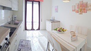 Eine moderne Küche mit Essbereich, ausgestattet mit einer Kaffeemaschine, einer Blumenschale und einem dekorativen Leuchter.