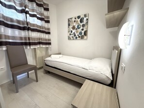 A small, neatly arranged bedroom with a single bed, a chair, and a wall-mounted artwork. - Casa Palanca Holideal (Tremosine)
