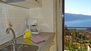 Eine Küche mit Kaffeemaschine, Spüle und Meerblick.