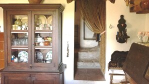 A traditional room with a wooden cabinet displaying various dishes and a large vase.