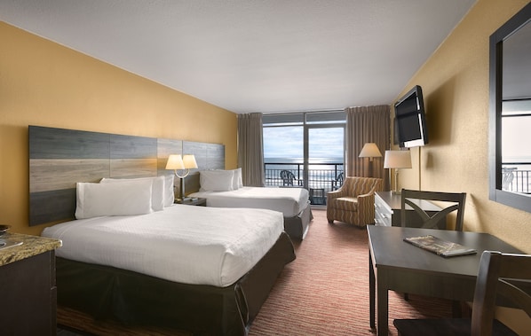 A hotel room with two beds, a desk, a chair, a TV, and a balcony with a view. - Beautiful Oceanfront Guest Room + Official On-Site Rental Privileges (Myrtle Beach)