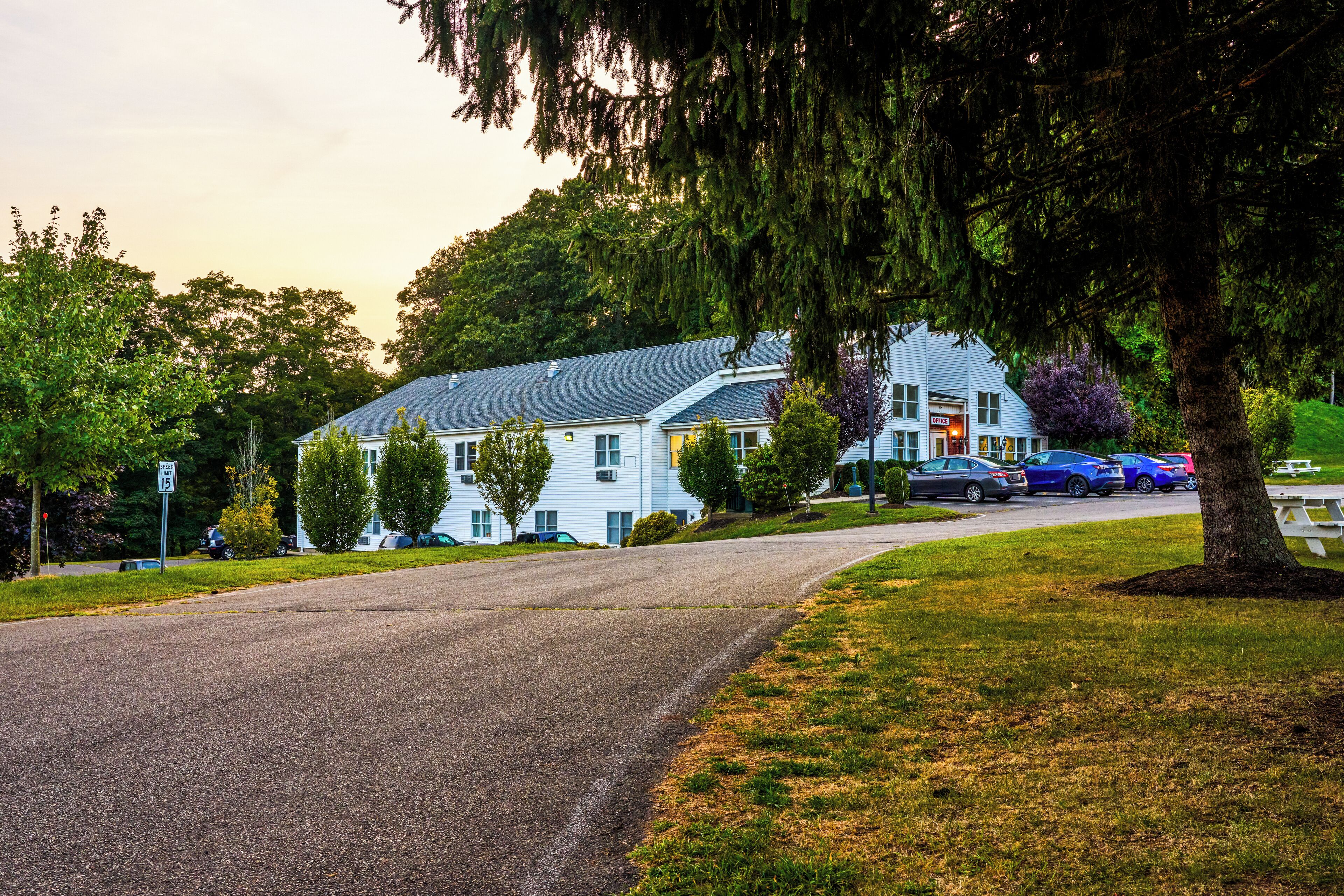 A two-story building with a driveway leading to a parking area.