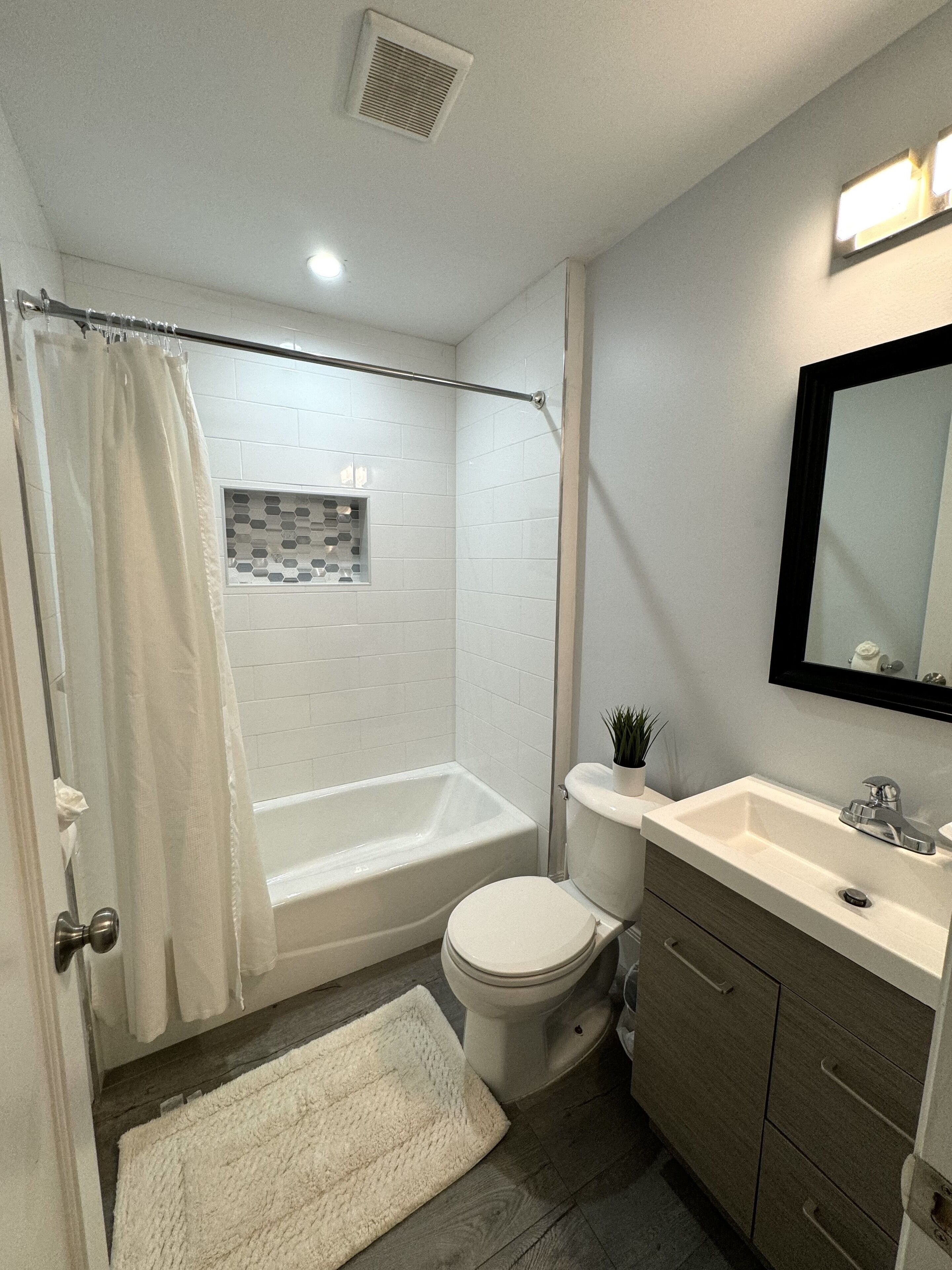 A bathroom with a bathtub, toilet, and sink.