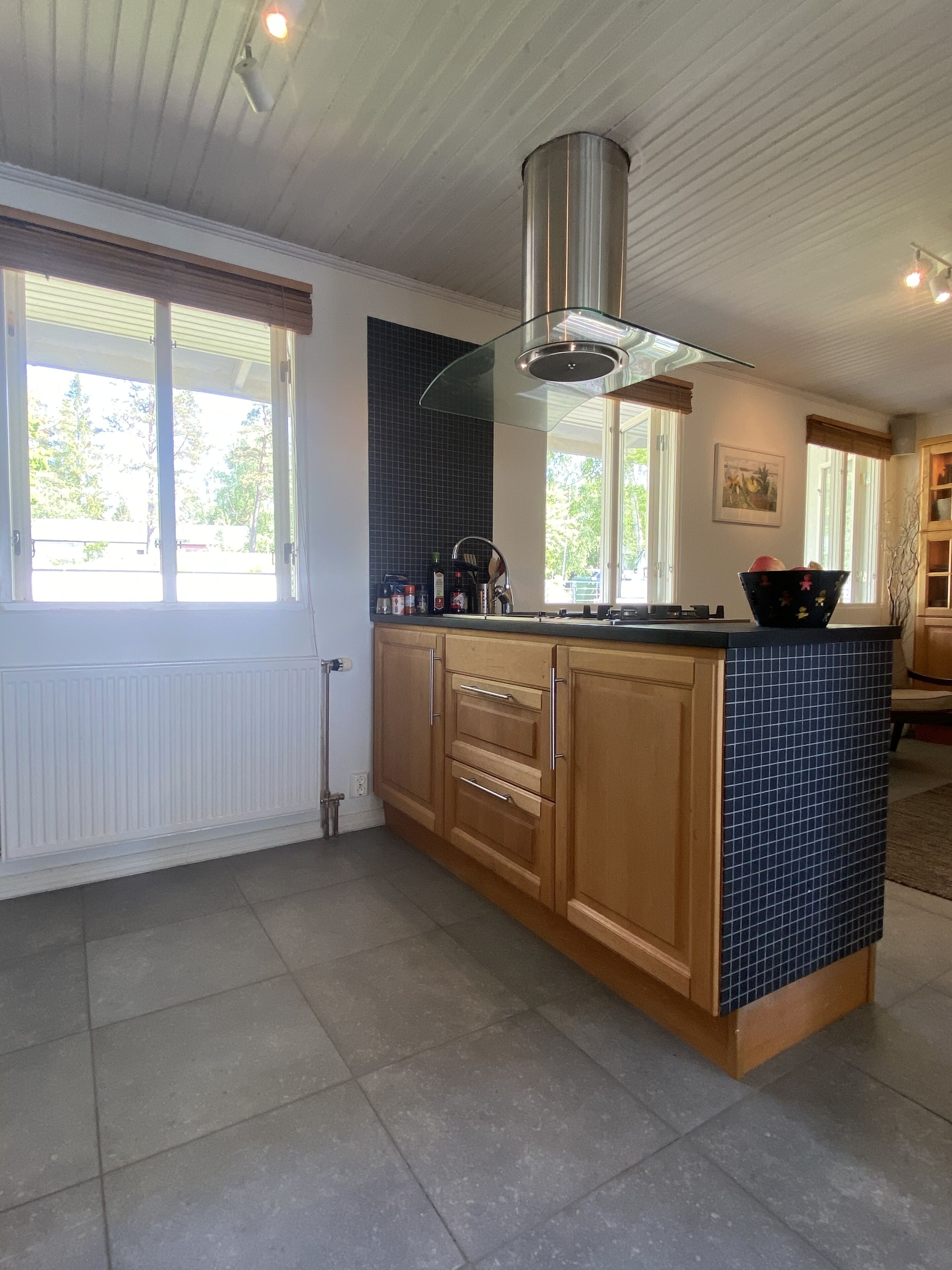Una cocina moderna con armarios de madera, una campana extractora de acero inoxidable y un salpicadero de azulejos.