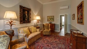 A living room with a patterned rug, a sofa, armchairs, and a wooden cabinet. - Beautiful apartment at one step from the Dome. Perfect for families! (Florence)