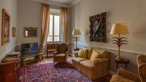 A living room with a television, armchairs, a sofa, patterned rug, and decorative lamps. - Beautiful apartment at one step from the Dome. Perfect for families! (Florence)