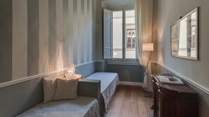 A room with two beds, a wooden dresser, a lamp, and a window with curtains. - Beautiful apartment at one step from the Dome. Perfect for families! (Florence)