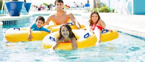 A pool area with inflatable tubes, lounge chairs, and umbrellas.