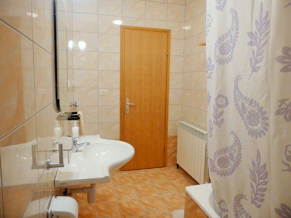 A bathroom with a sink, toilet, and shower area.