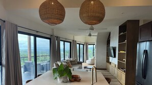 A modern kitchen with a large island, a built-in refrigerator, and a dining area with a view. - Spectacular 270 degree ocean/mountain VIEWS, very private, recently remodeled (Nosara)