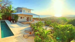 A modern house with a swimming pool, outdoor seating, and a view of the ocean. - Spectacular 270 degree ocean/mountain VIEWS, very private, recently remodeled (Nosara)