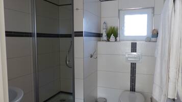 Een bad/douchecombinatie, een haardroger, zeep, toiletpapier