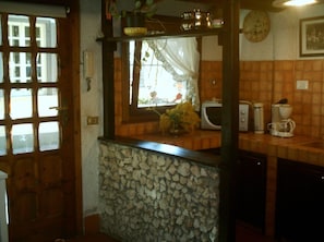 Kitchen area with a window above the sink, microwave, and coffee maker.