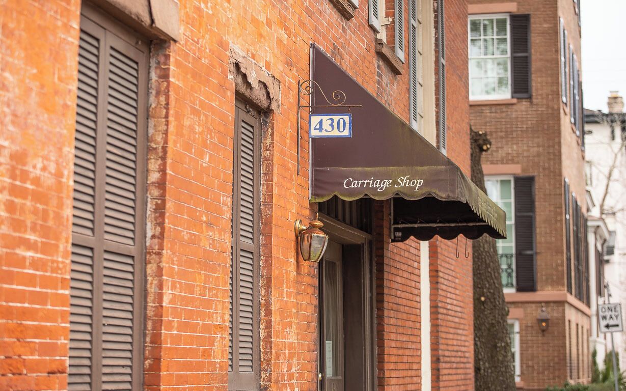 Un bâtiment en briques avec une devanture portant l’inscription « Atelier de fabrication de carrosses », situé au numéro 430.