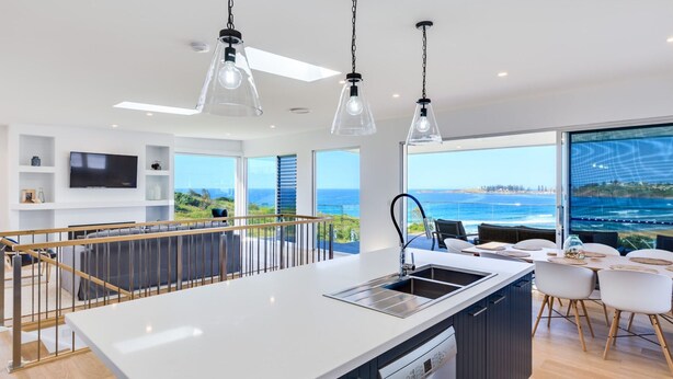 A modern kitchen with a central island, large windows, and a view of the ocean. - Seascape, Bombo, South Coast (Bombo)
