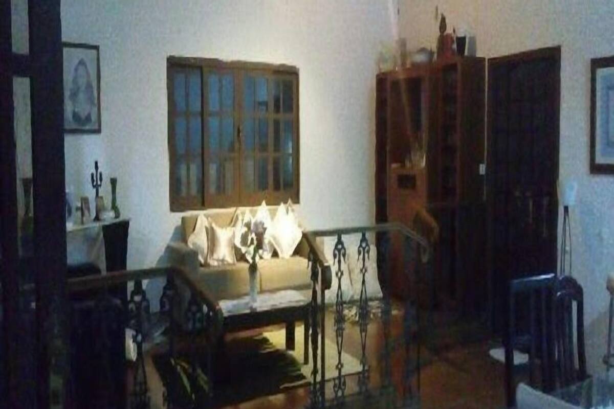 A living room with a sofa, a glass coffee table, and a wooden cabinet.