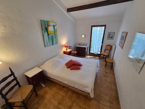 A bedroom with a bed, a desk, a chair, a lamp, and a window. - Provencal house in the heart of the Luberon with garden and large swimming pool (Mérindol)