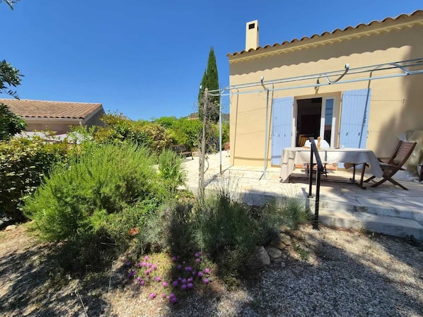 A house with a patio, a table, and a chair. - Provencal house in the heart of the Luberon with garden and large swimming pool (Mérindol)