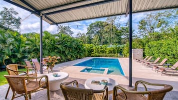 Una piscina al aire libre, sillones reclinables de piscina