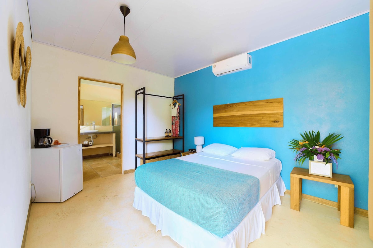 Un dormitorio con cama, mesita de noche y espejo.