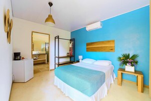 Un dormitorio con cama, mesita de noche y espejo.