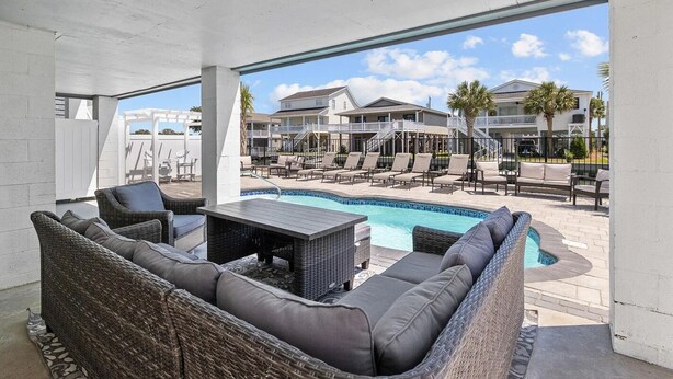 Un espace extérieur abrité comprenant une piscine, des chaises longues et une table à manger.