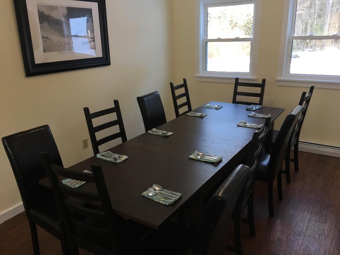 A dining area with a long table and six chairs.