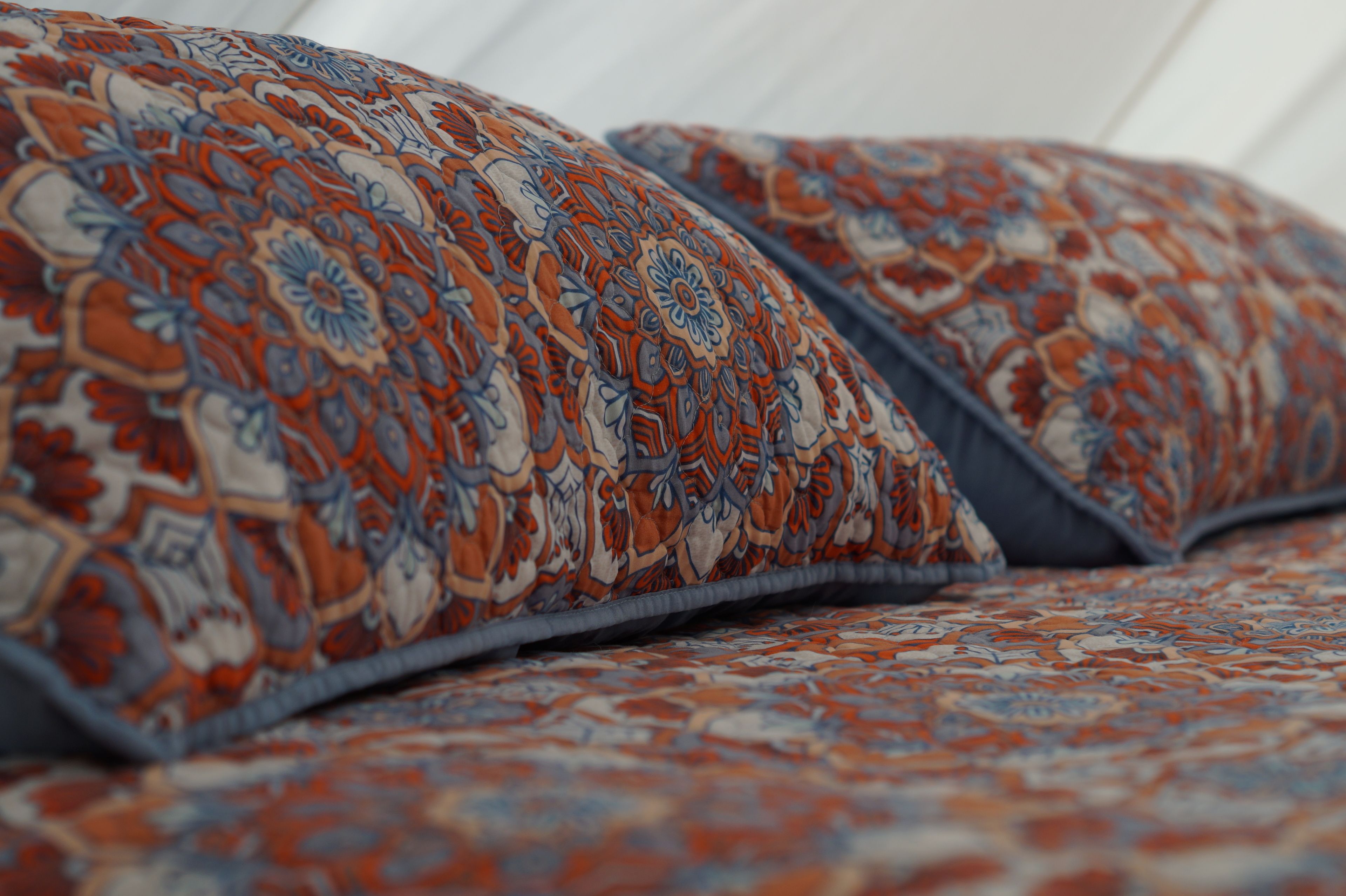 A patterned bedspread with a floral design.