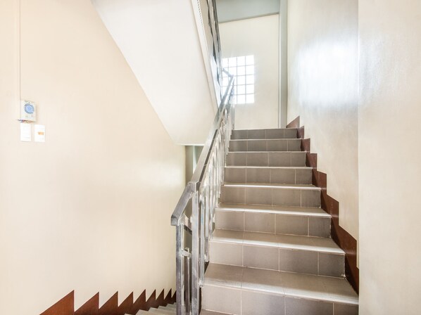A staircase with a metal railing and beige walls. - OYO 443 Maria Cristina Arcade Suites (Cebu City)