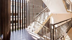 Una escalera moderna con barandilla de metal que conduce a un piso superior.