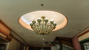 A chandelier with multiple lights and a circular ceiling design. - La Fiesta Hotel (Iloilo)