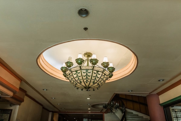 Un lustre doté de plusieurs lampes et orné d’un motif circulaire au plafond.