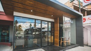 A modern building with large glass windows and a wooden facade. - La Fiesta Hotel (Iloilo)