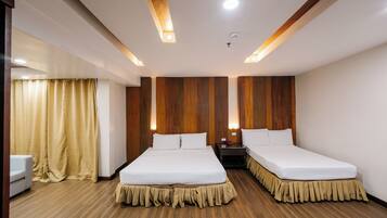 A hotel room with two beds, wooden panel walls, and a wooden floor.