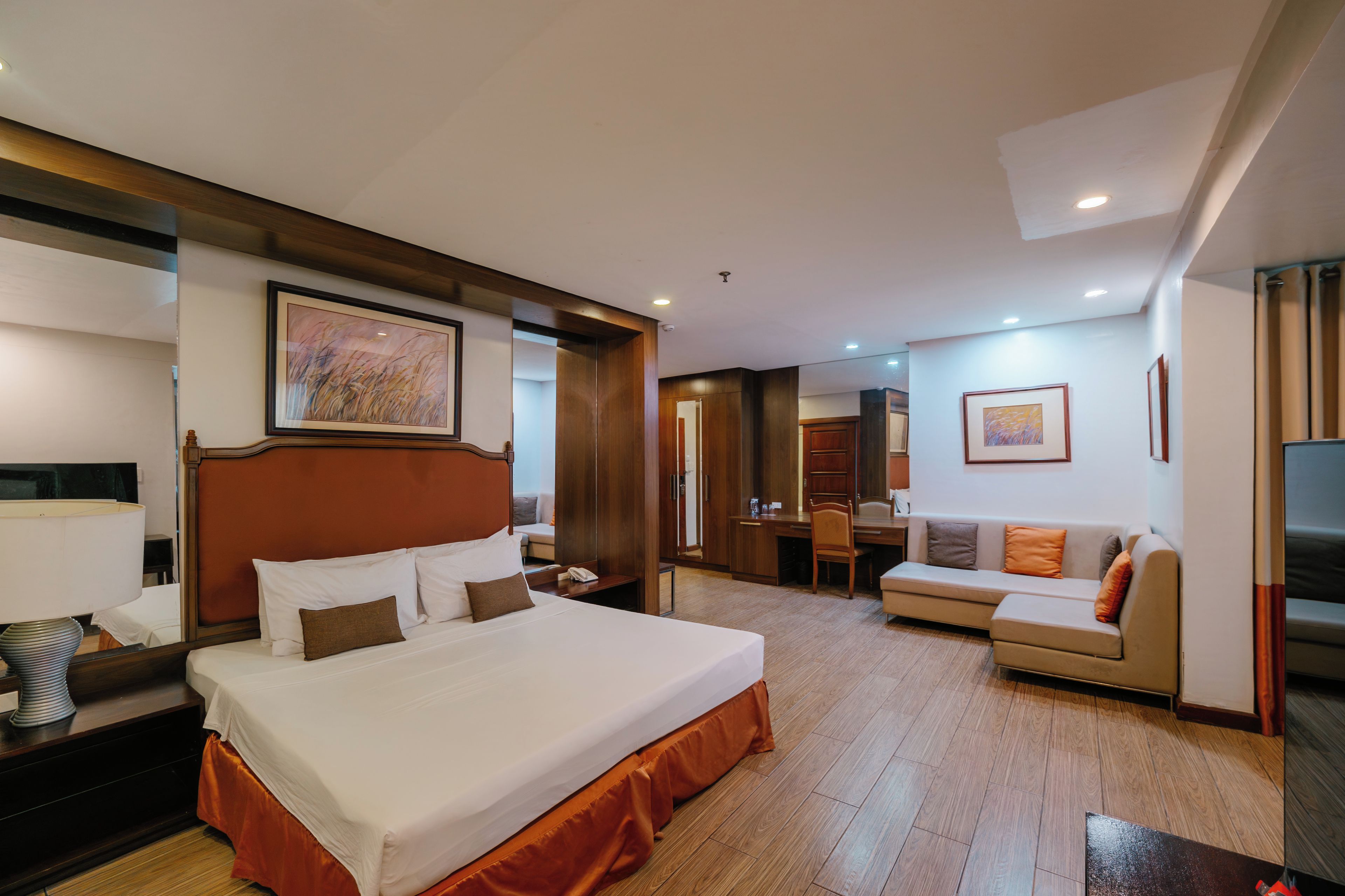 Une chambre d’hôtel avec un grand lit, un canapé, un bureau et une télévision.
