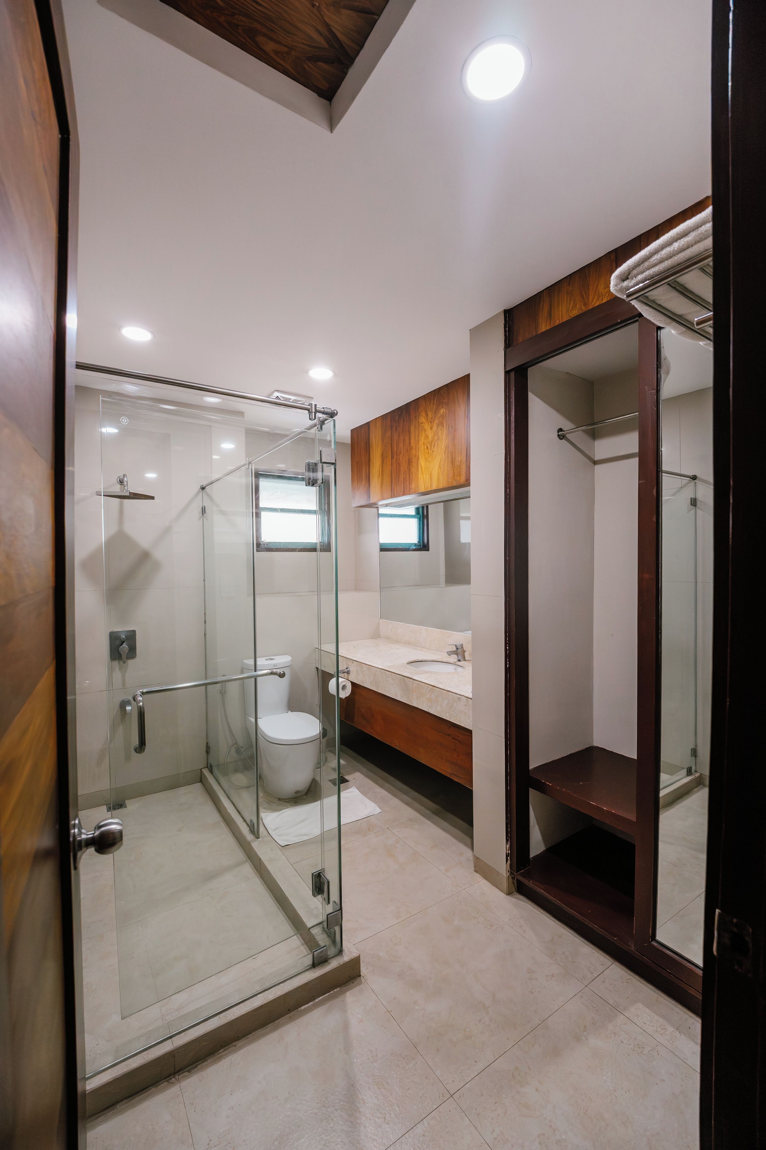 Une salle de bain moderne avec une douche à parois de verre, des toilettes et un meuble-lavabo avec un miroir.