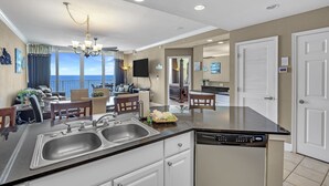Una cocina moderna con lavavajillas, doble pileta y comedor con vistas.