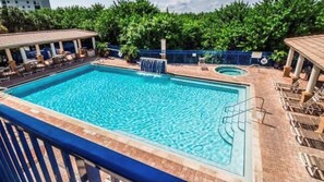 Relax by the pool with lounge chairs and a hot tub nearby.