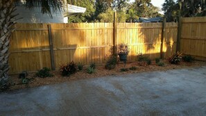 backyard oasis with potted plants and a gravel path leading to the entrance.