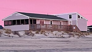 A beach house with a porch and a staircase leading to the entrance. - HipNautical Oceanfront (Kitty Hawk)