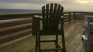A wooden deck with a green Adirondack chair facing the ocean. - HipNautical Oceanfront (Kitty Hawk)