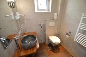 A compact bathroom with a stone basin, a toilet, a shower, and a towel rack. - Deluxe Studio Kaprun TOP 12 (Kaprun)