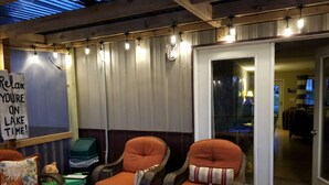 A cozy outdoor seating area with wicker chairs and a sign that reads "Relax you're on lake time!" - Lake front with dock and Beautiful view  (Afton)