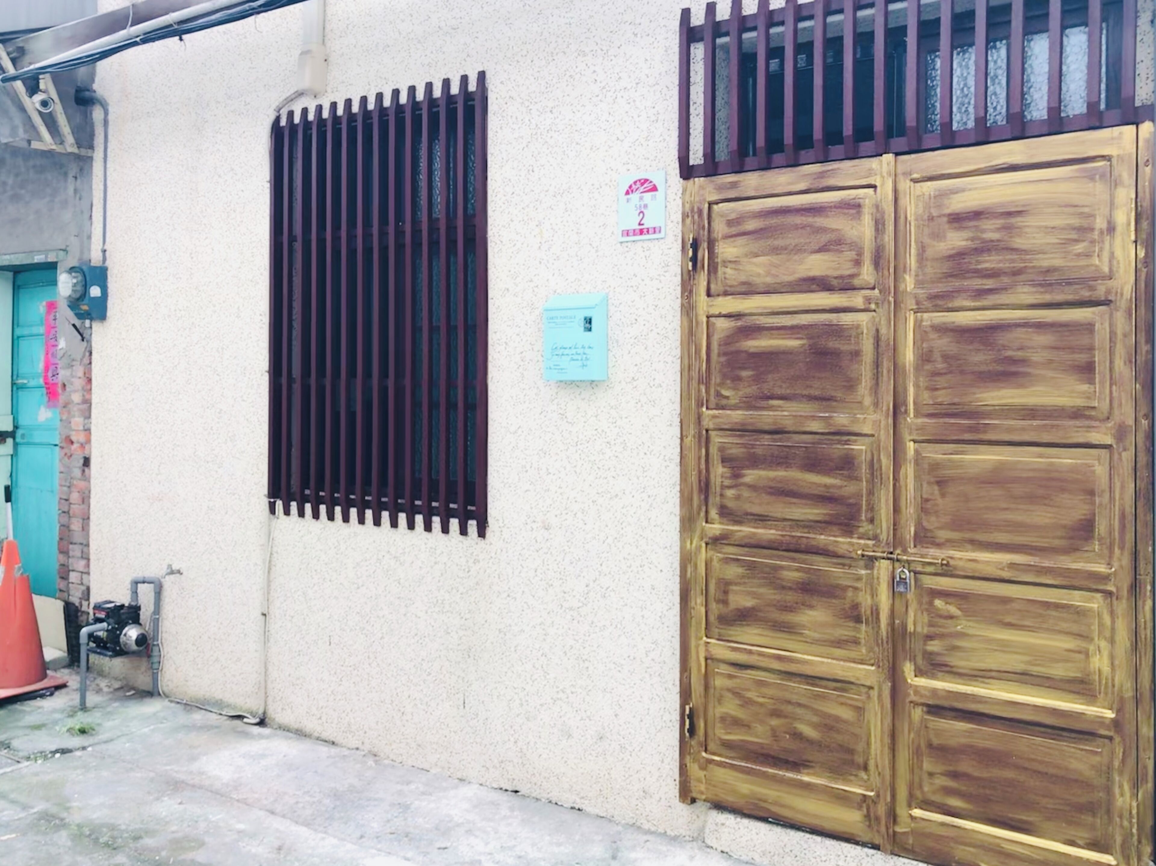 A building with a large wooden door and a barred window.