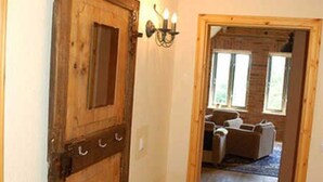 Una puerta de madera con un picaporte metálico y una lámpara de pared.