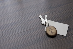 A wooden keychain with a blank tag on a wooden surface. - Just Like Villa (Ji'an)